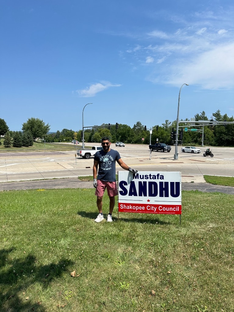 Man posing with a political campaign sign