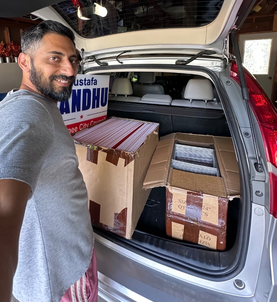 Man loading campaign materials into a car trunk