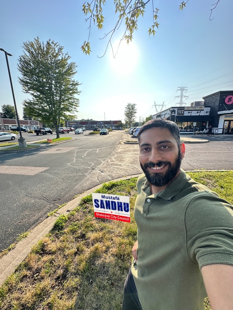 Man posing with a political campaign sign