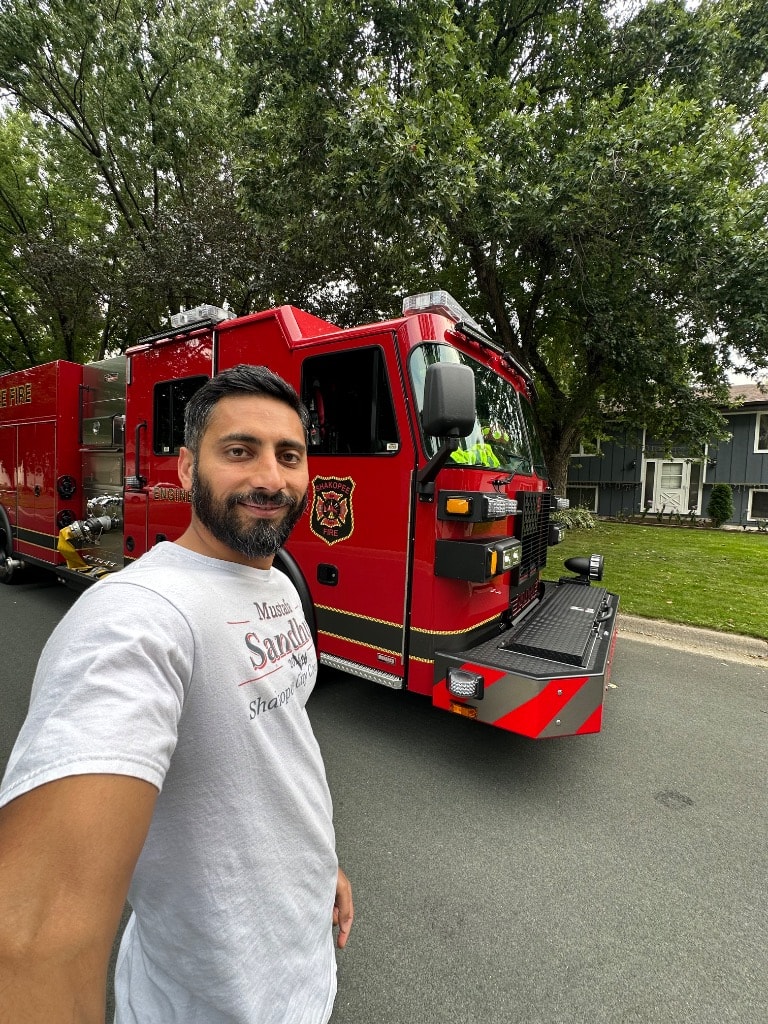 Man posing with a red fire truck