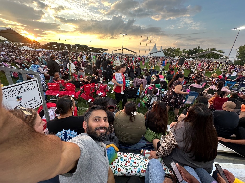 Large outdoor festival crowd at sunset