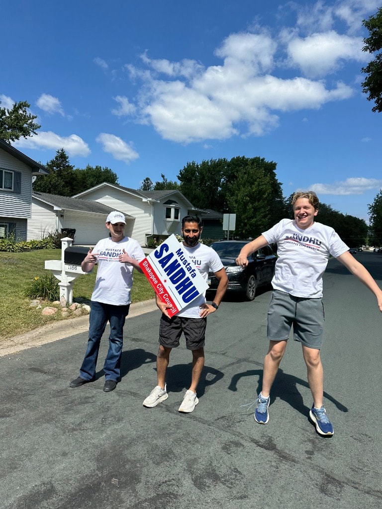 Campaign volunteers holding signs on a residential street