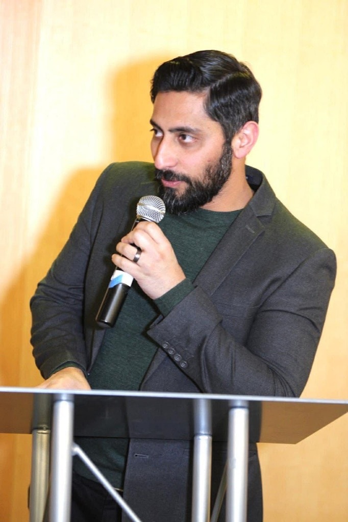 Man speaking into a microphone at a podium