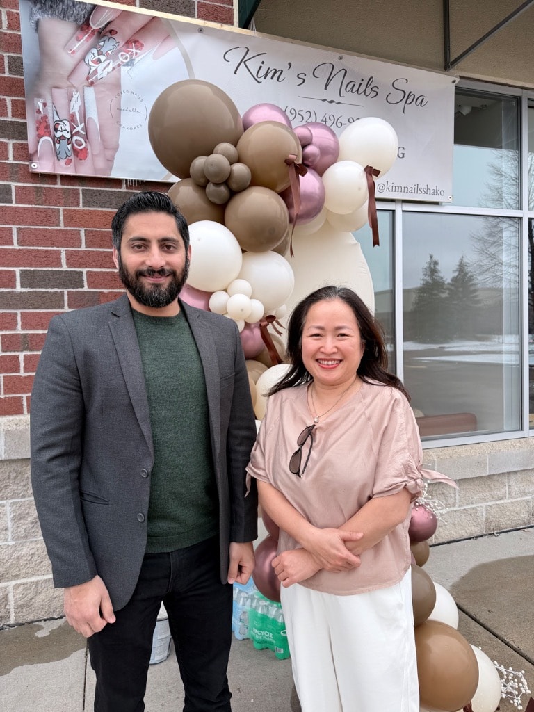 Two people outside Kim's Nails Spa storefront