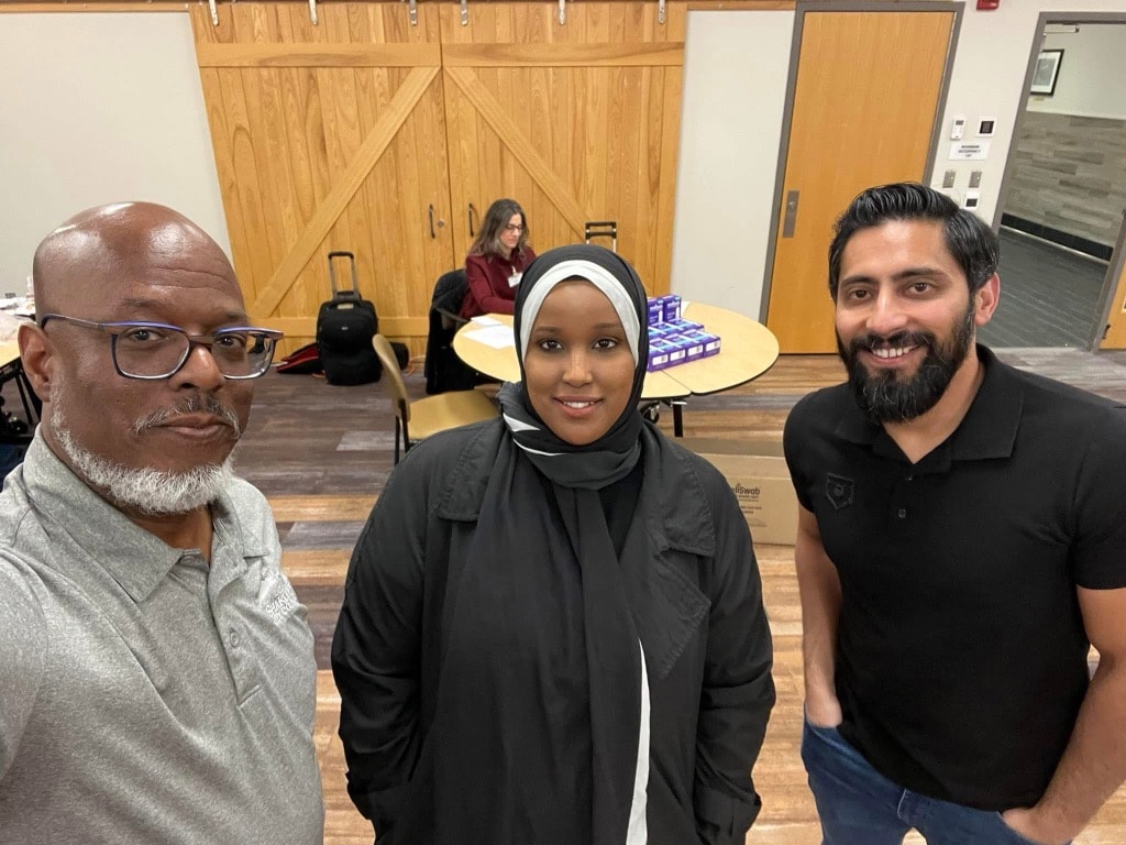 Three people smiling at a community center gathering