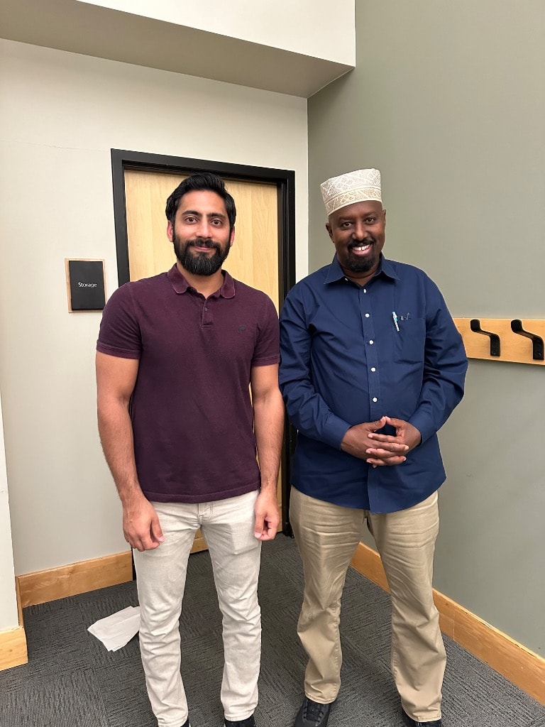 Two men smiling inside a modern office space