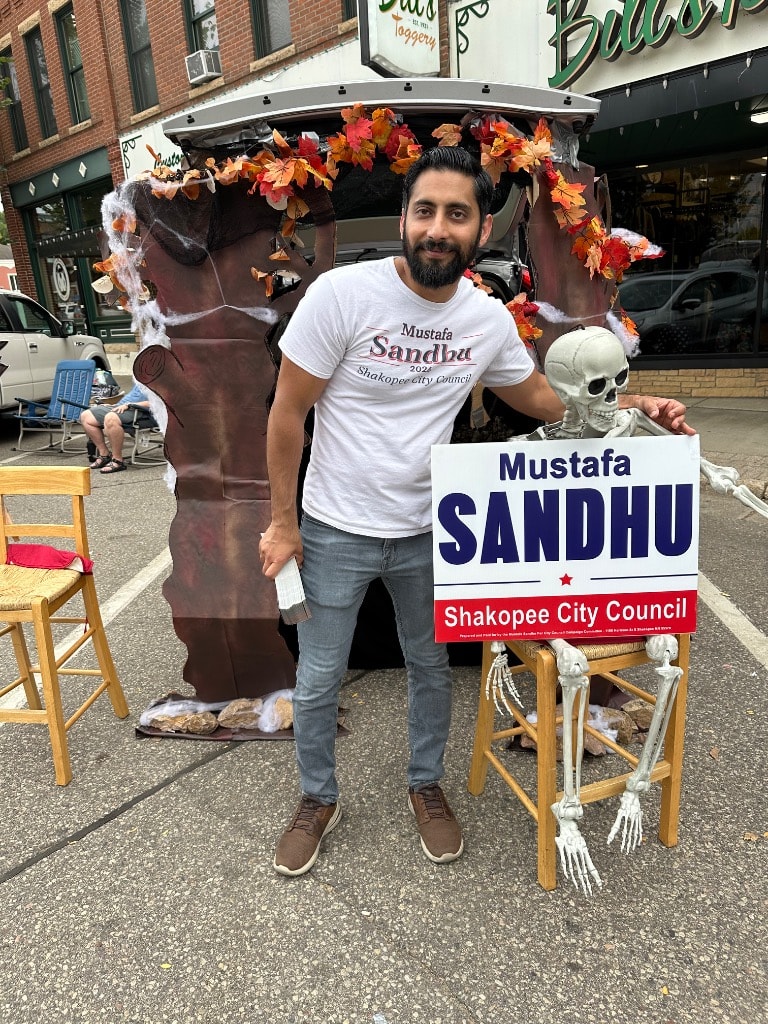Mustafa Sandhu with campaign sign at a Trunk or Treat event