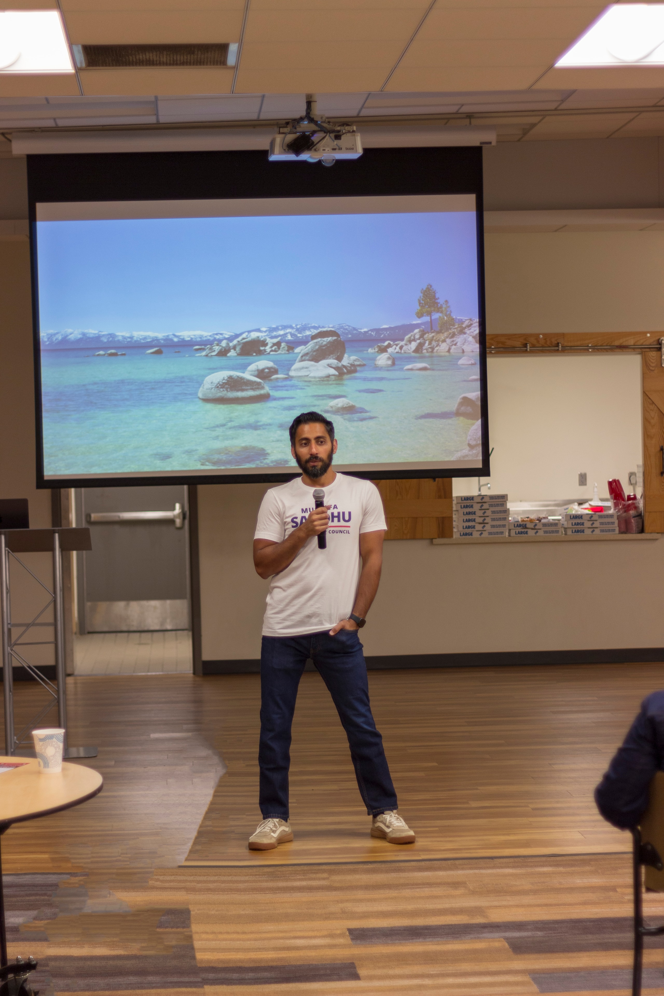 Mustafa Sandhu presenting at a meet and greet event