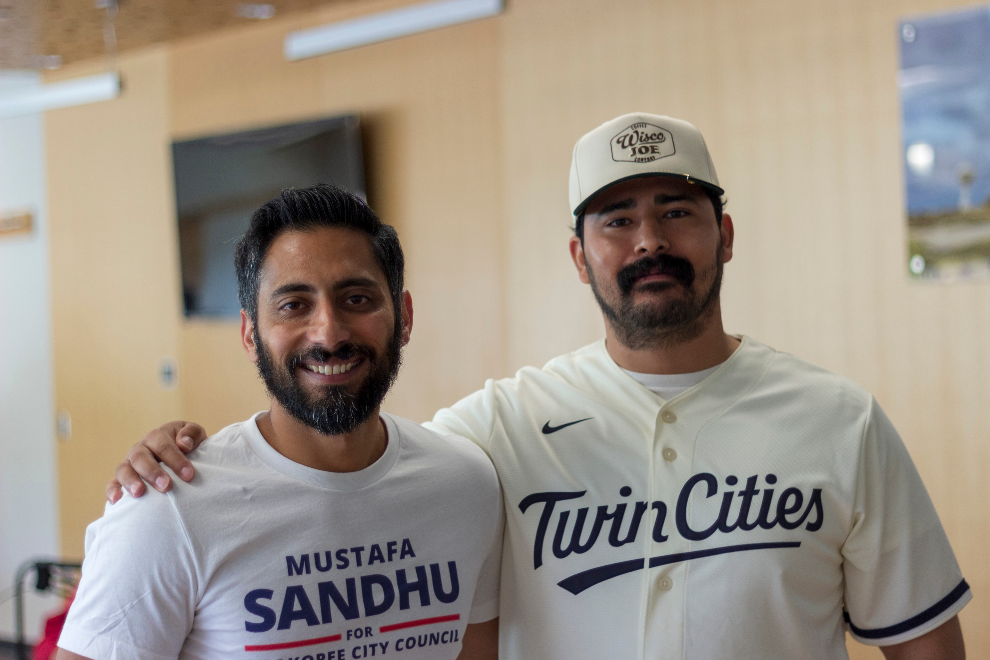 Mustafa Sandhu posing with a supporter in a Twin Cities jersey