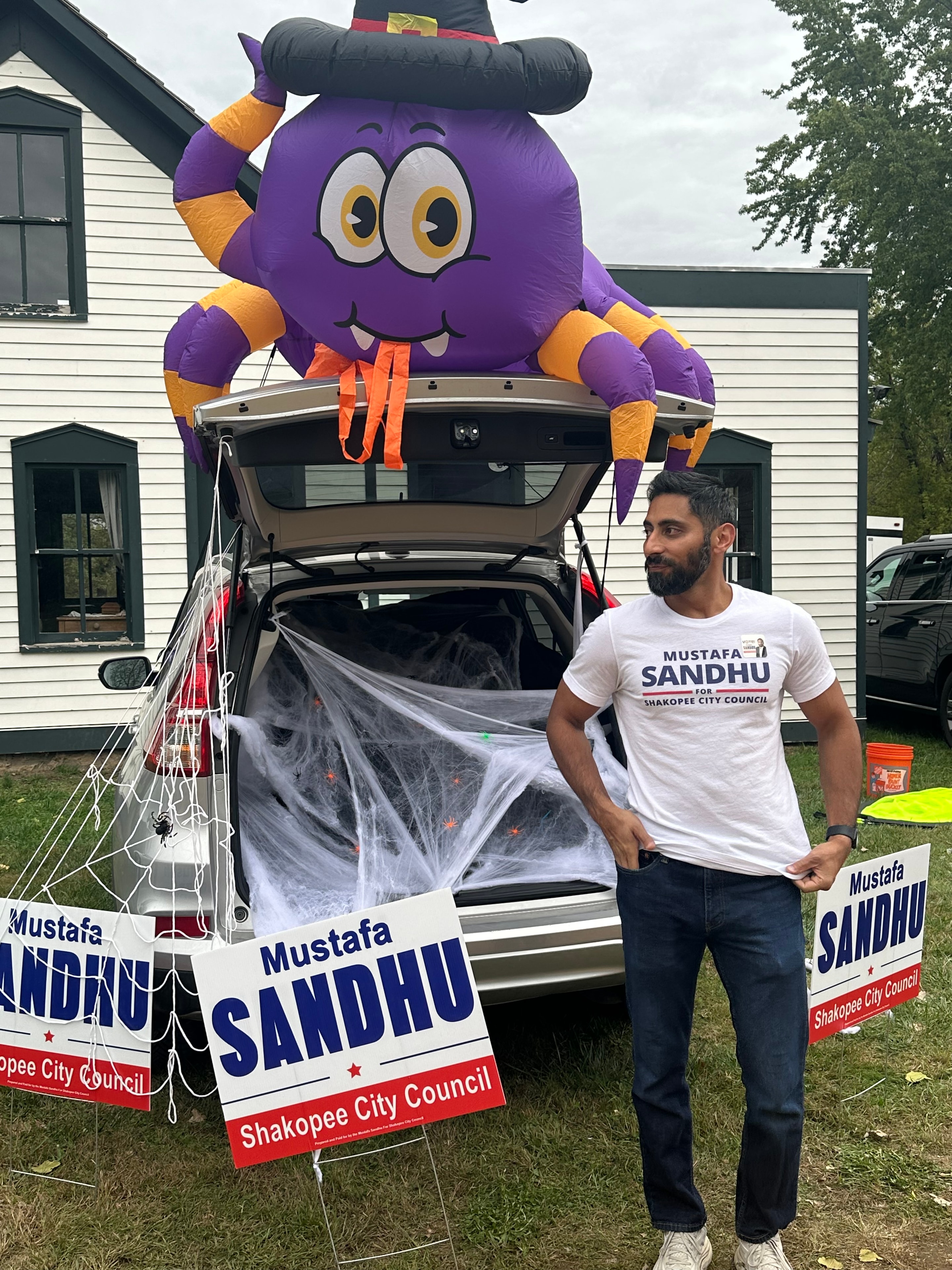 Mustafa Sandhu setting up campaign signs and decorations at the trunk-or-treat