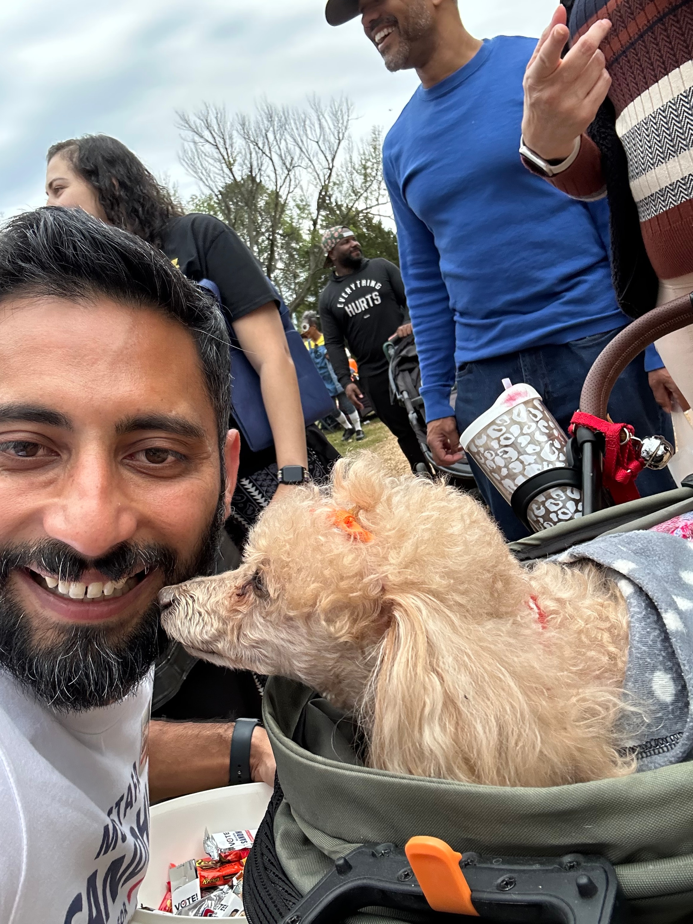 Mustafa Sandhu selfie with a fluffy dog at the trunk-or-treat community event