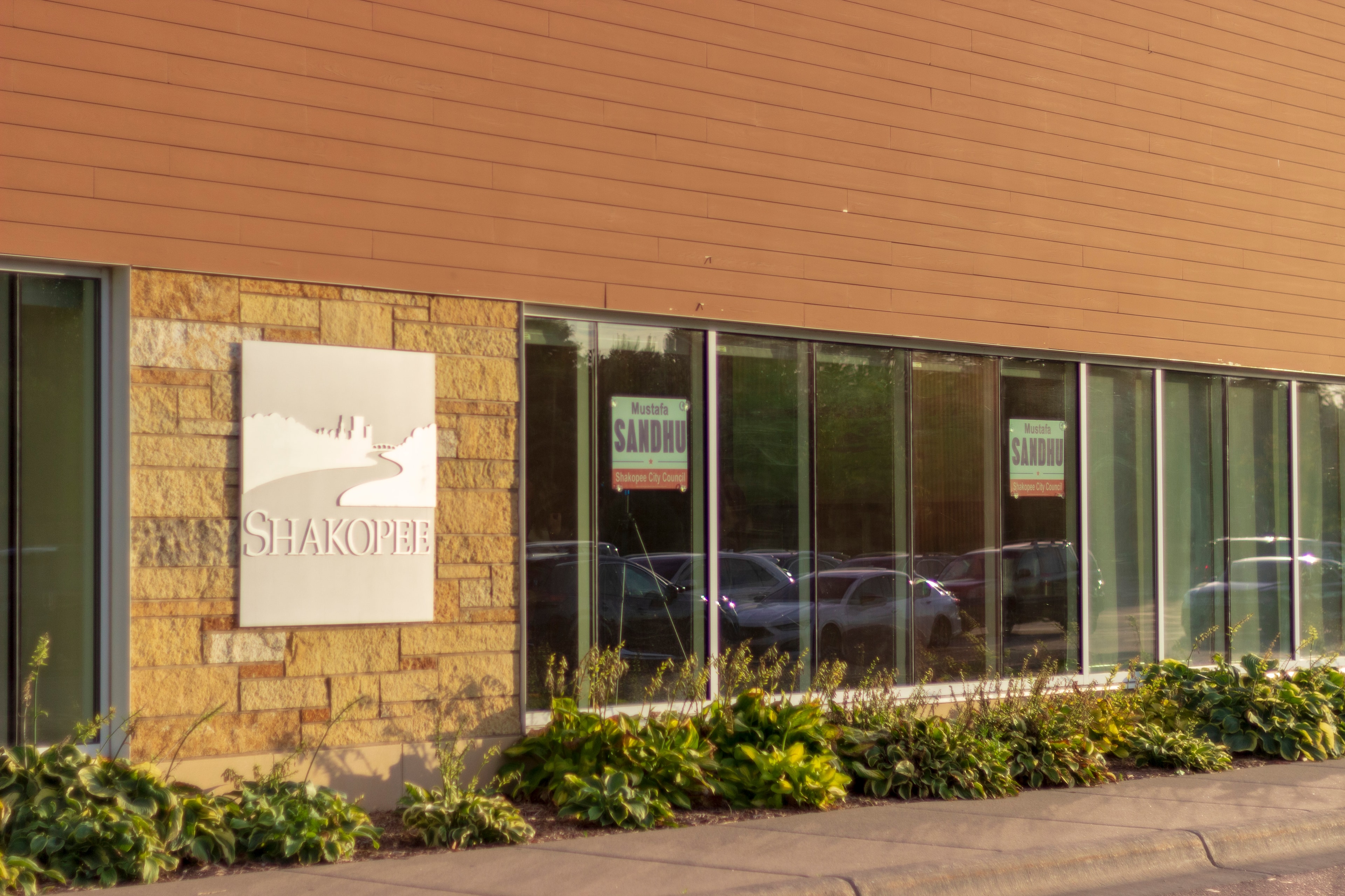 Shakopee city hall exterior with Sandhu campaign signs in windows