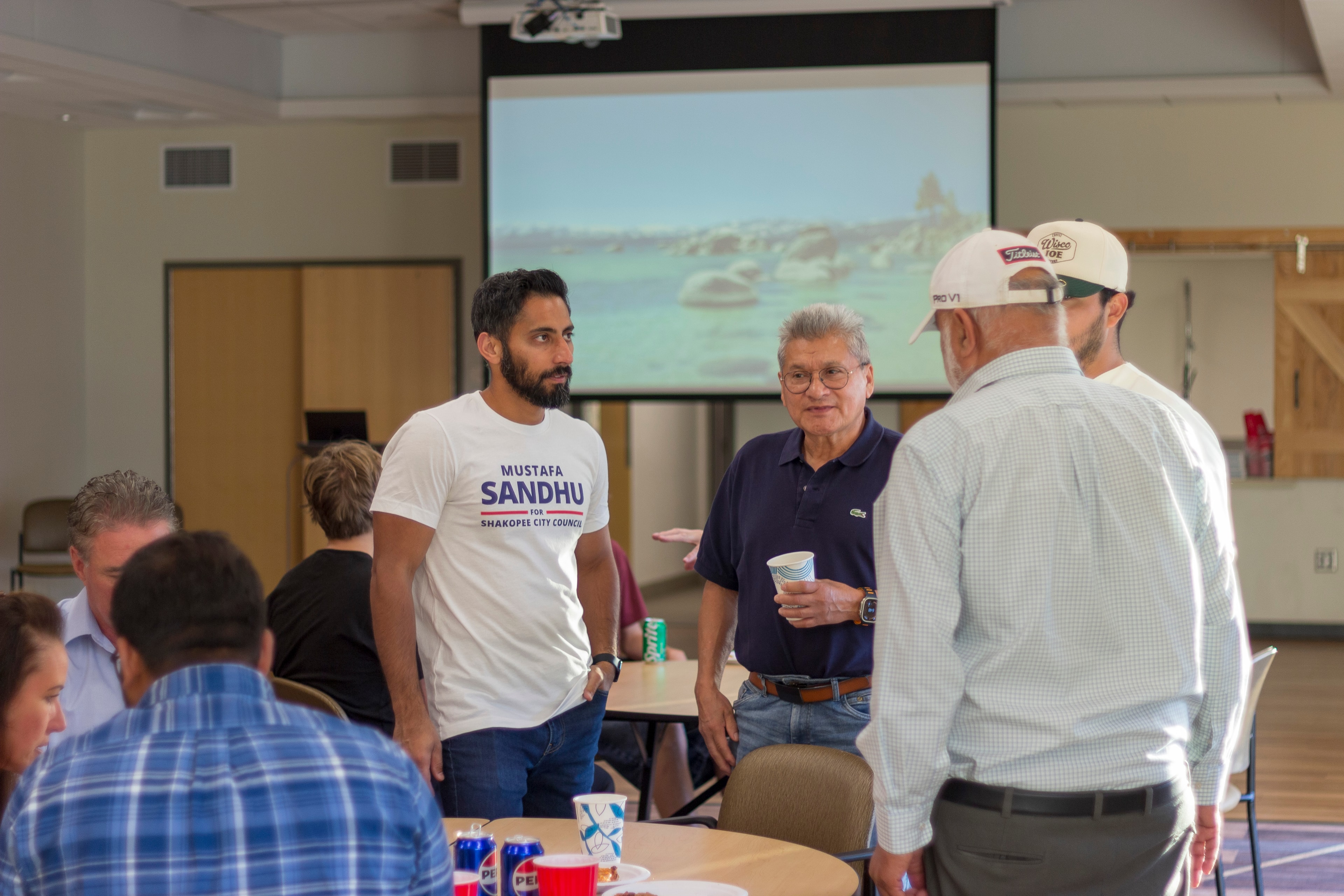 Group of community members gathered at tables at Mustafa Sandhu meet and greet event